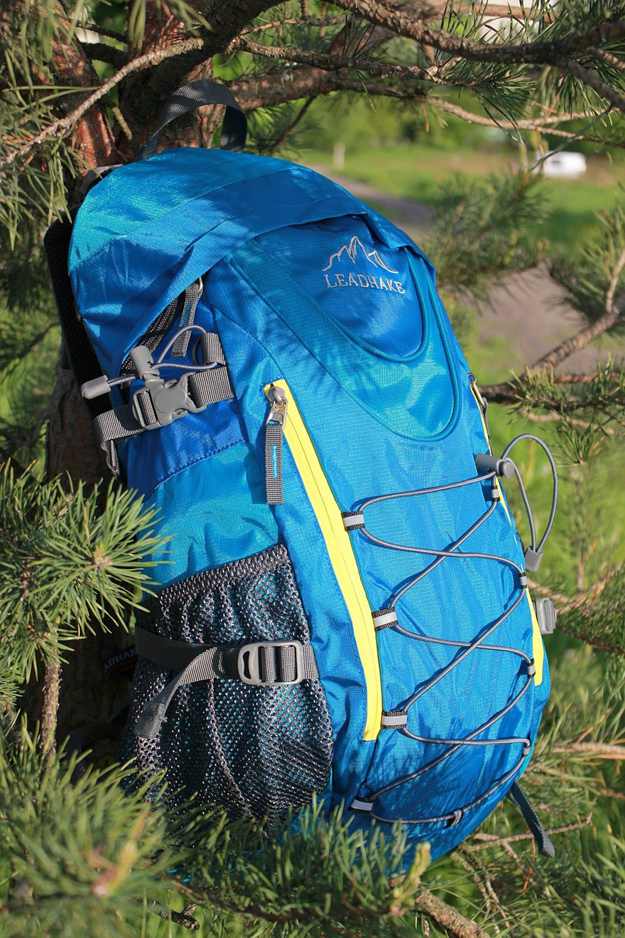 bue backpack on side of tree | Camping Checklist For The Wild Man