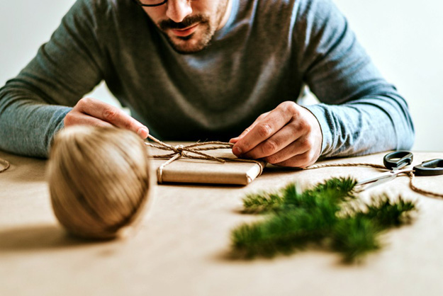 man wrapping gifts | How To Wrap A Gift Like A Pro