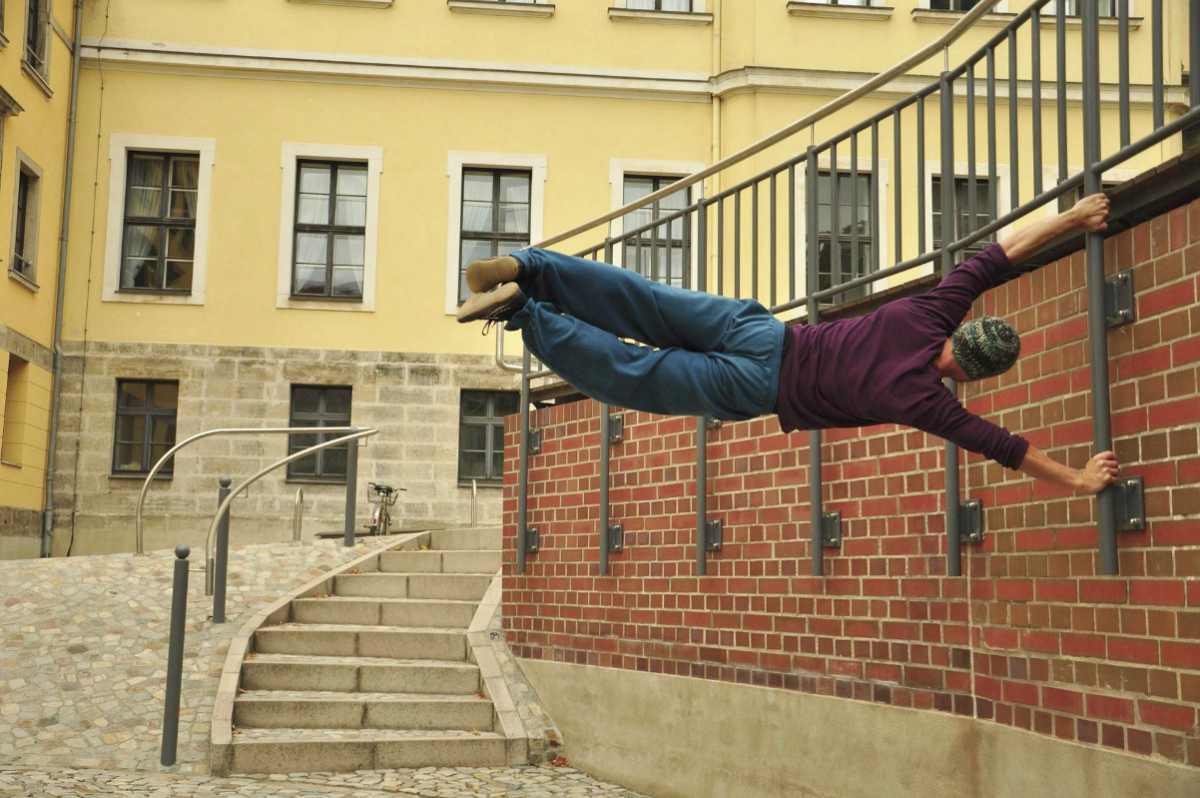 Man swinging on the wall | What Is Parkour? | All You Need To Know To Get Started