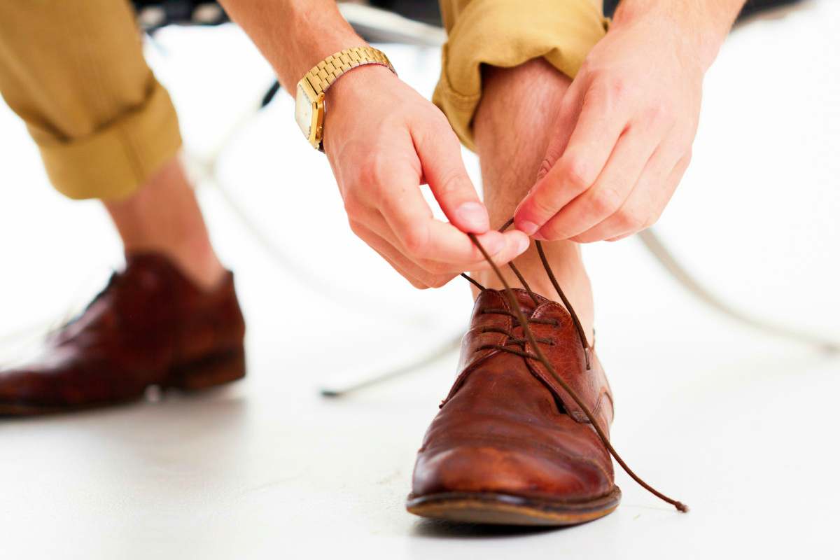 man tying his business shoes | What NOT to Wear On A First Date (Unless You Don't Want a Second Date)