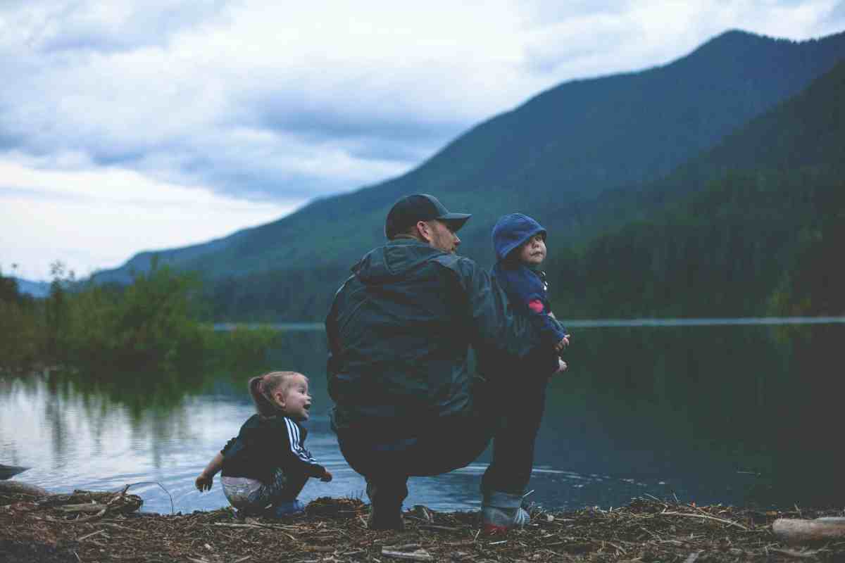 dad with two kids near lake | A Dad’s No *BS* Tips For Camping With Kids | camping essentials with toddlers 